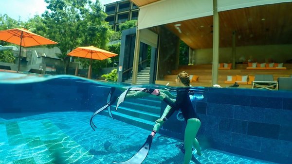 Pool fin training in clear water with a mermaid-style movement line