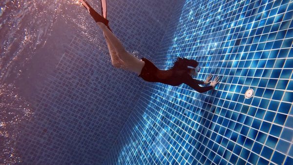 Freediver descending in clear blue water