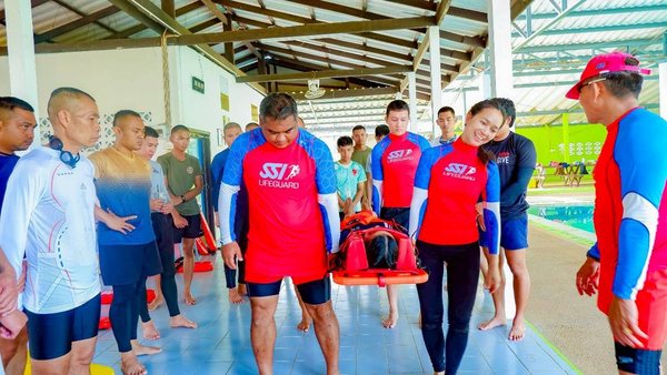 Lifeguard trainees coordinating a rescue-equipment practice session