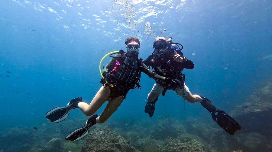 Two supervised scuba divers posing calmly during a training dive