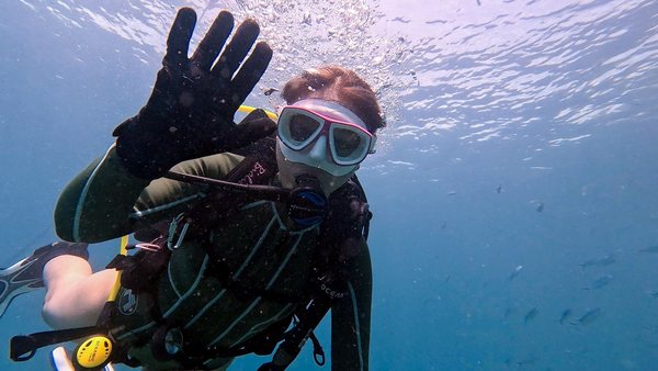 Scuba student waving during a supervised underwater session
