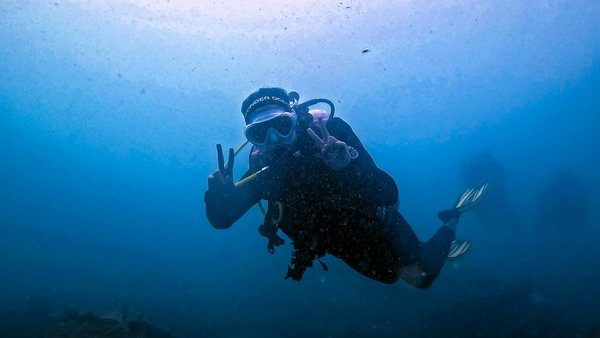 Scuba diver signaling calmly in blue water